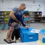 Un niño vota con su padre en un colegio electoral de Tel Aviv