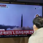 Una pantalla de televisión que muestra un programa de noticias que informa sobre el lanzamiento de misiles de Corea del Norte con imágenes de archivo se ve en la estación de tren de Seúl
