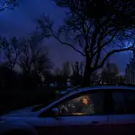 Una mujer se sienta en un coche después de que las luces se apagaran debido a los cortes de energía programados que se introdujeron en Kyiv