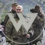 Visitantes vestidos con camuflaje militar frente a la entrada principal del Centro Wagner en San Petersburgo, Rusia