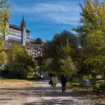 Dos personas pasean a la orilla del rio Turia a su paso por Teruel este domingo
