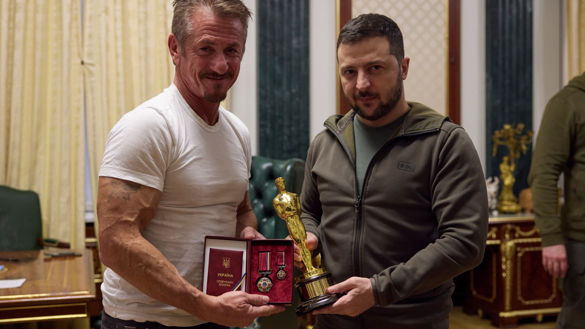 El actor Sean Penn (izda.) entrega un Oscar al presidente Ucraniano, Volodímir Zelenski (dcha.) y recibe una condecoración