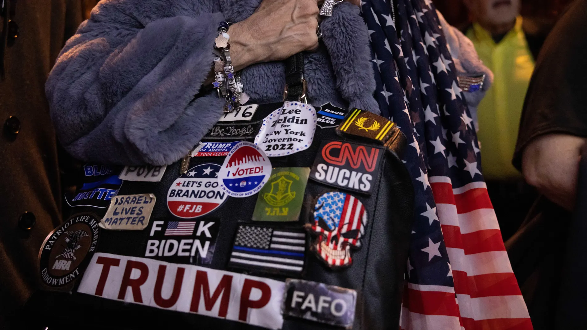 Una mujer sostiene una bolsa cubierta con pegatinas políticas pro-Trump mientras los partidarios ven los resultados en vivo durante una fiesta de observación de las elecciones para el candidato republicano a gobernador de Nueva York Lee Zeldin en la ciudad de Nueva York