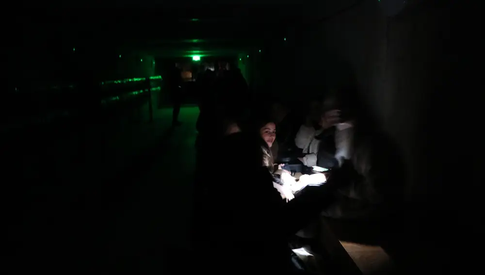 Personas sentadas en la oscuridad en un refugio antibombas durante las sirenas aéreas en Leópolis