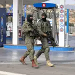 Dos efectivos israelíes patrullan la gasolinera en la que se produjo el atropello y apuñalamiento del terrorista palestino este martes