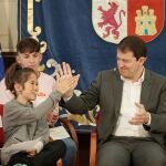 Fernández Mañueco choca las manos con una joven miembro del Foro de Participación de la Infancia y la Adolescencia de Castilla y León