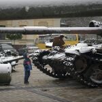 Un niño observa tanques dejados por Rusia en medio de la nieva en Kyiv