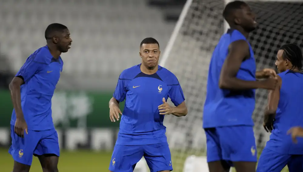 France's Kylian Mbappe, center, stretches with teammates during a training session on the eve of the group D World Cup soccer match between France and Australia, in Doha, Qatar, Monday, Nov. 21, 2022. (AP Photo/Christophe Ena)