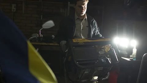 El residente local Danylo prepara un generador durante un apagón en Kyiv