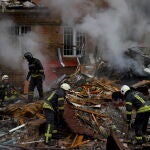 Los bomberos trabajan en el lugar de un bloque de apartamentos destruido por un bombardeo en Vyshhorod