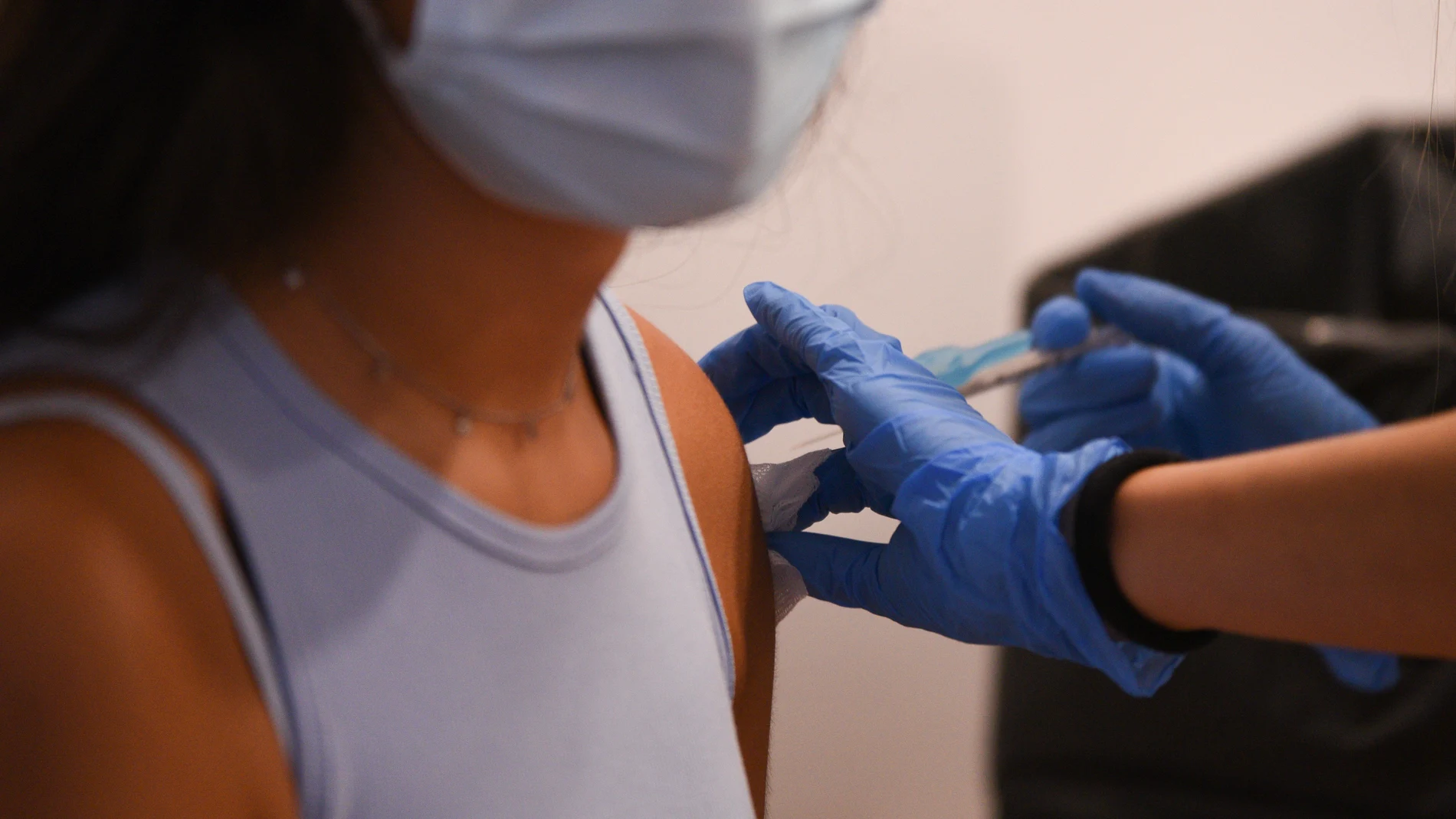 Una adolescente recibe la primera dosis de la vacuna Pfizer en el punto de vacunación de Xátiva.