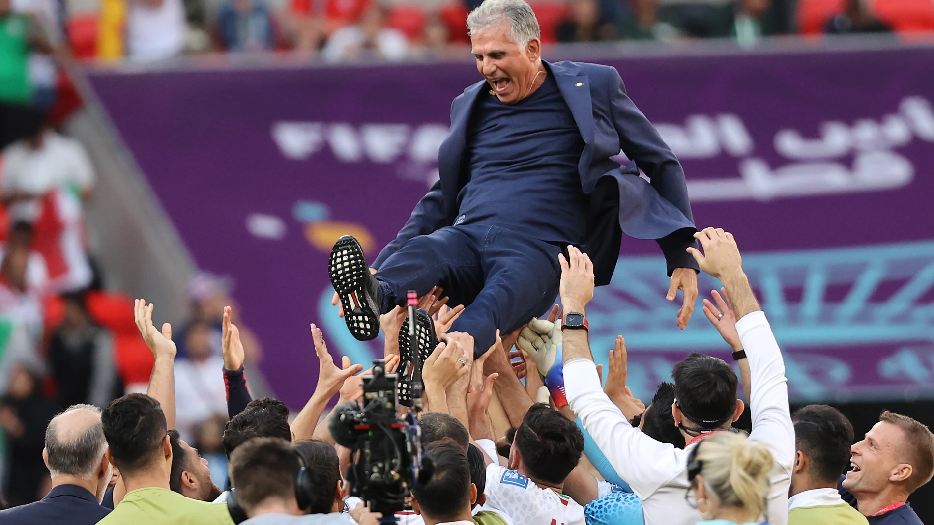 Los jugadores de Irán mantean a su seleccionador, Carlos Queiroz, después de su triunfo ante Gales