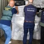 Efectivos de la Agencita Tributaria y Guardia Civil inspeccionando la carga del contenedor con hachís en el puerto de Cádiz
