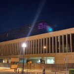 Imagen de la ventana del despacho del PSOE en la cuarta planta de las Cortes iluminado de morado