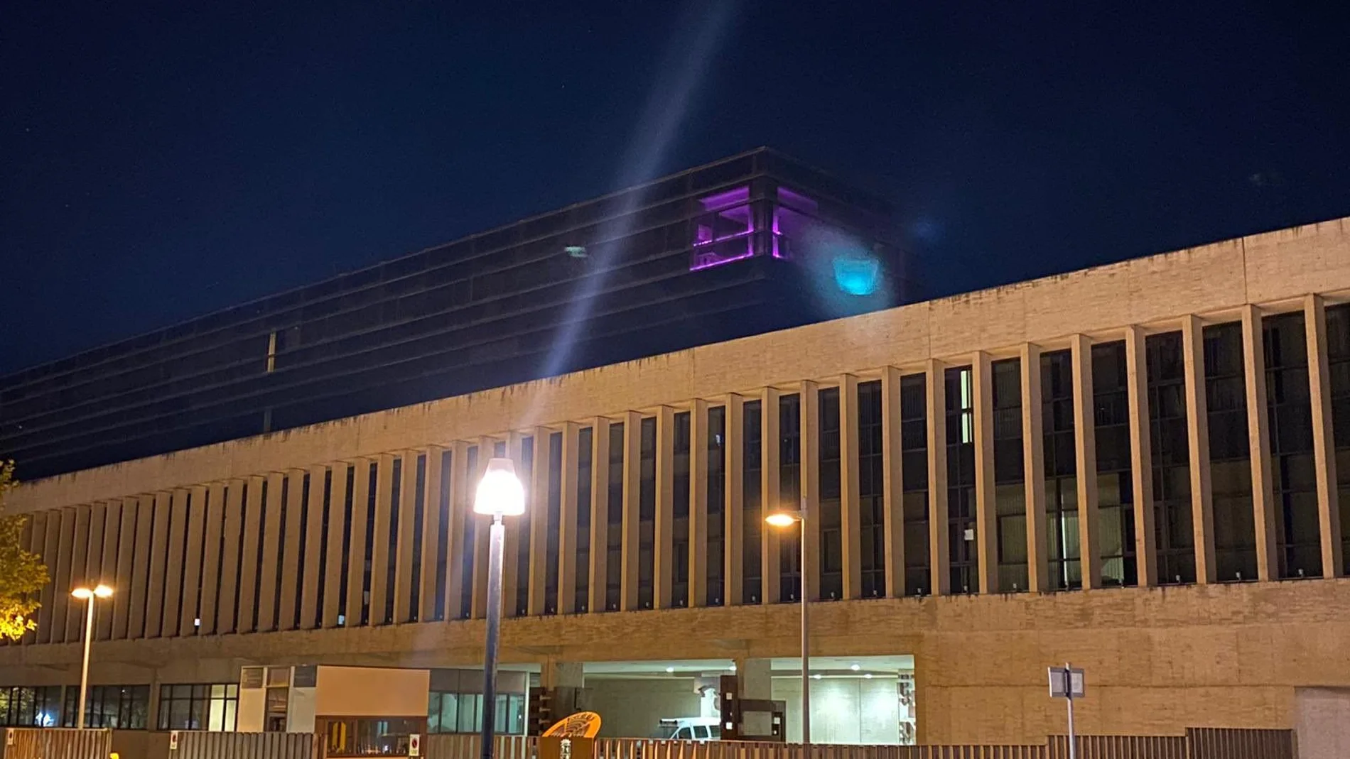 Imagen de la ventana del despacho del PSOE en la cuarta planta de las Cortes iluminado de morado