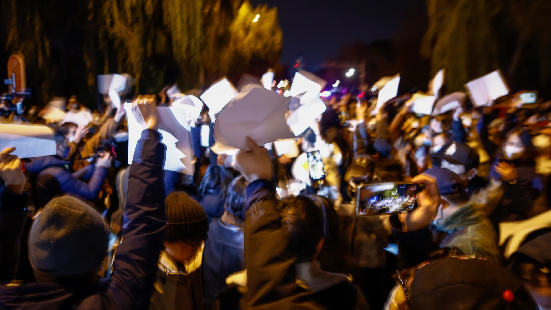 Manifestantes agitan hojas de papel en blanco durante una protesta en Pekín, China