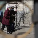 Imagen de dos personas mayores paseando por Madrid