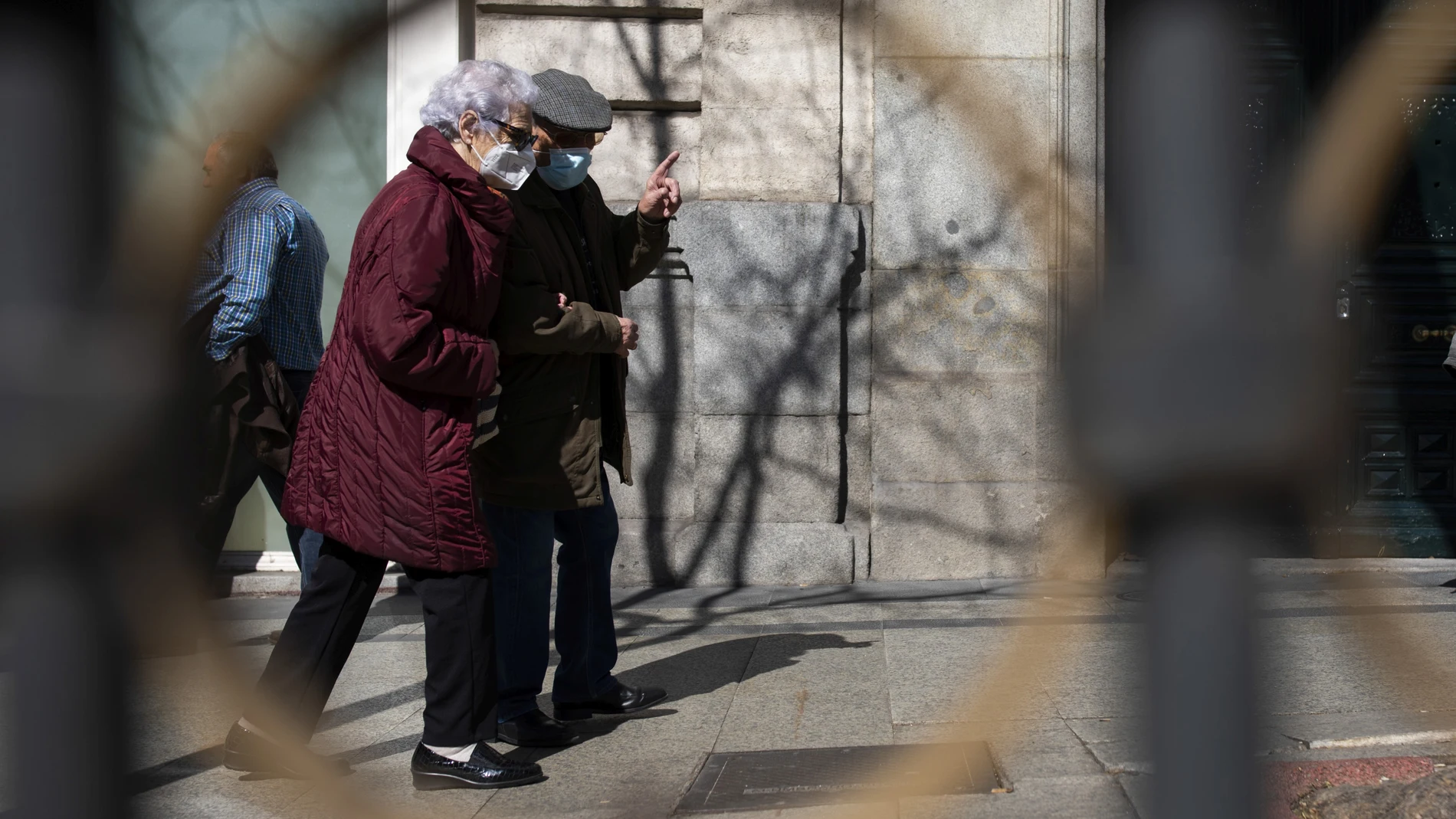 Imagen de dos personas mayores paseando por Madrid