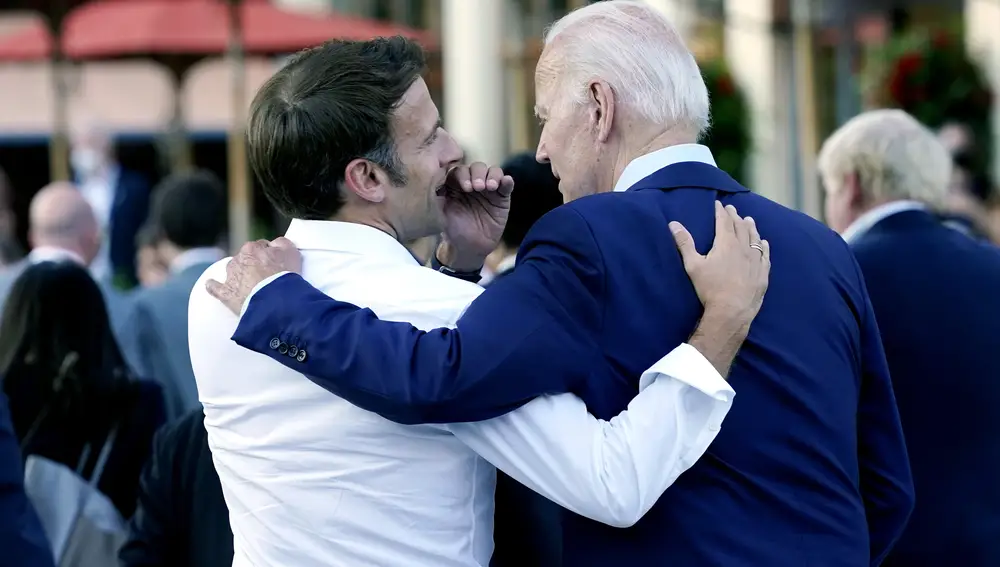 El presidente francés, Emmanuel Macron, cuchichea con su homólogo estadounidense, Joe Biden en el G-7, este verano