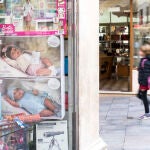 Una menor camina por la calle junto al escaparate de una tienda de juguetes este miércoles en el centro histórico de Mahón