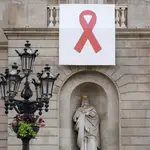 El ayuntamiento de Barcelona colgó en su balcón un lazo rojo gigante para sensibilizar, visibilizar y mostrar su apoyo a las personas que viven con el VIH durante la conmemoración hoy del Día Mundial de la lucha contra el sida