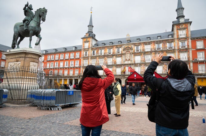 Unos turistas hacen fotografías en la plaza Mayor de Madrid