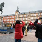 Unos turistas hacen fotografías en la plaza Mayor de Madrid