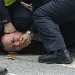 Un manifestante es reducido por un policía en Shanghái