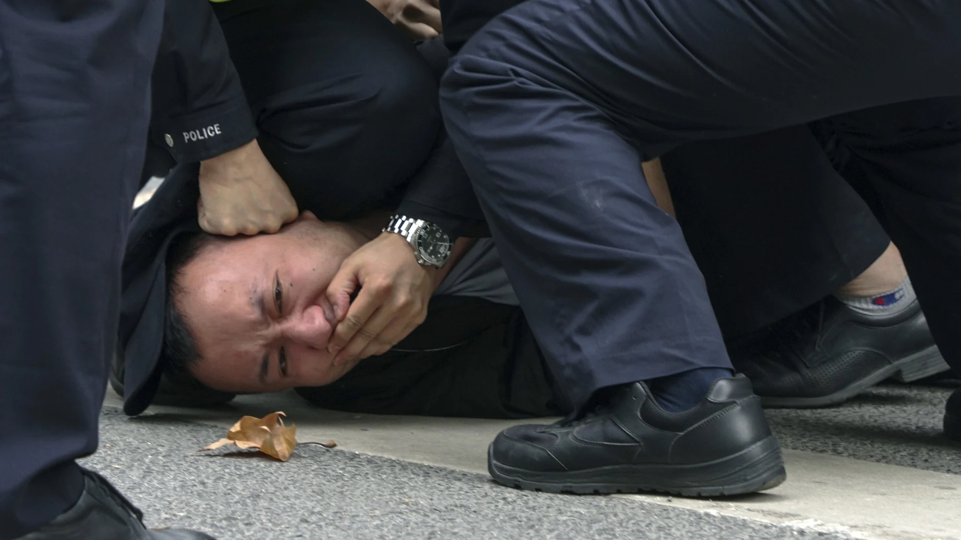 Un manifestante es reducido por un policía en Shanghái