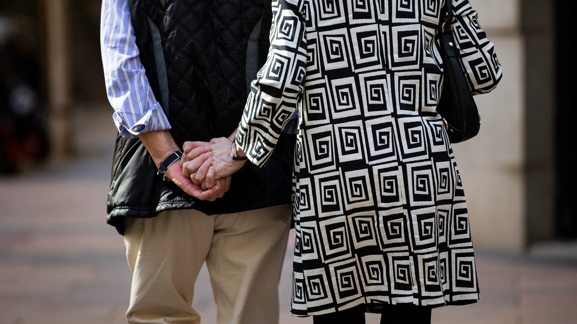 Imagen de una pareja de personas mayores paseando por Madrid