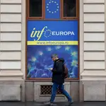 Un ciudadano pasea por un cartel de la Unión Europea en el centro de Bucarest, Rumania este jueves 8 de diciembre