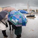 Varias personas se protegen de la lluvia en Madrid en una imagen de archivo