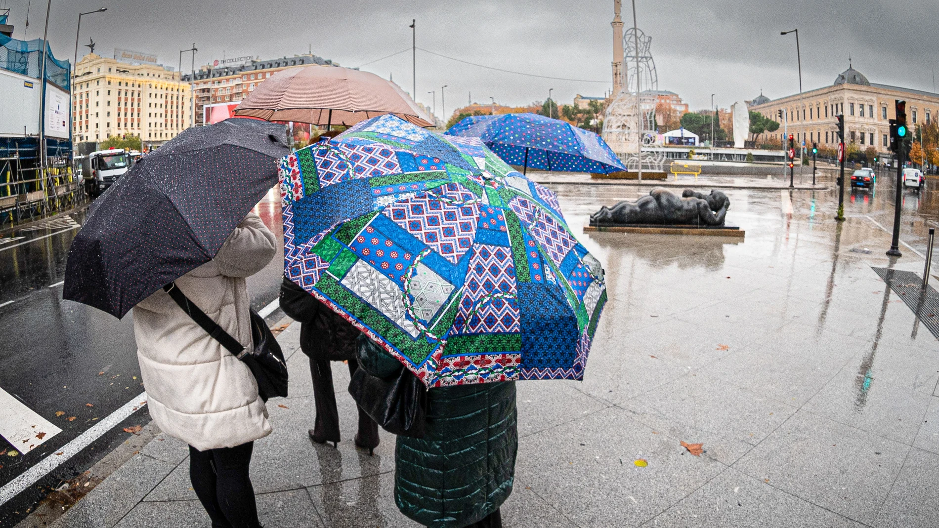 Varias personas se protegen de la lluvia en Madrid en una imagen de archivo