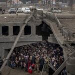 Una multitud de ucranianos trata de huir de Kyiv bajo un puente destruido por el Ejército ruso