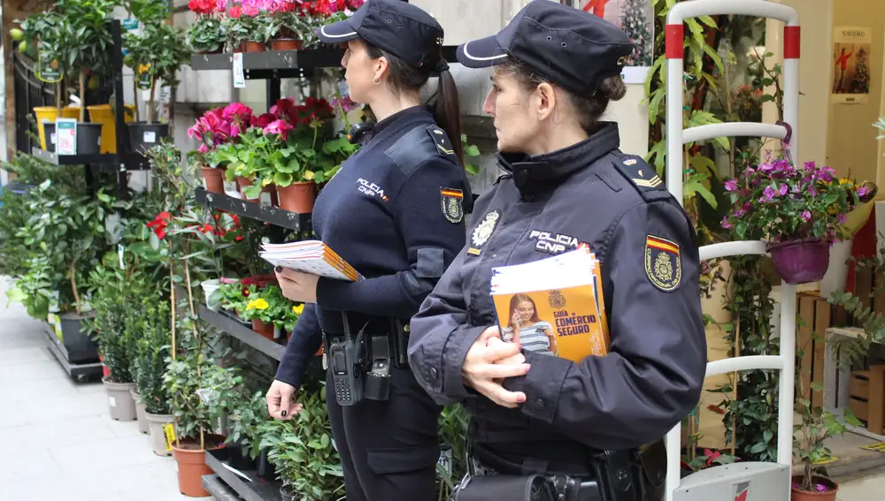 Dos agentes distribuyen la guía del comercio seguro en el centro de la ciudad