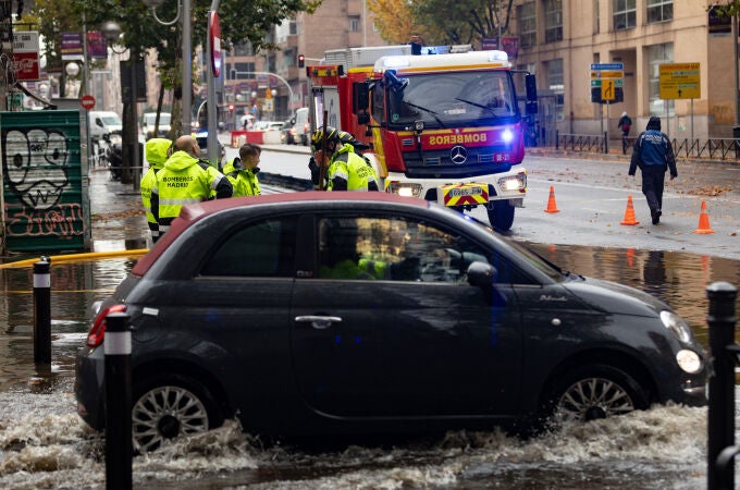 Un coche circula por una balsa de agua, en la Avenida de la Ciudad de Barcelona, a 14 de diciembre de 2022, en Madrid (España).