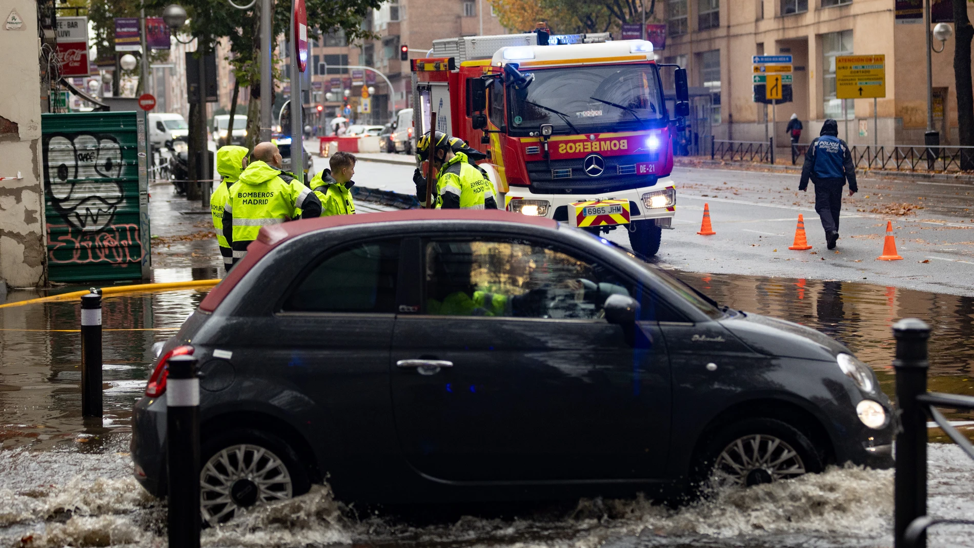 Un coche circula por una balsa de agua, en la Avenida de la Ciudad de Barcelona, a 14 de diciembre de 2022, en Madrid (España).