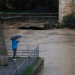 Una persona fotografía el estado en el que se encuentra el río Guadalquivir junto al Puente Romano en Córdoba. EFE/Salas