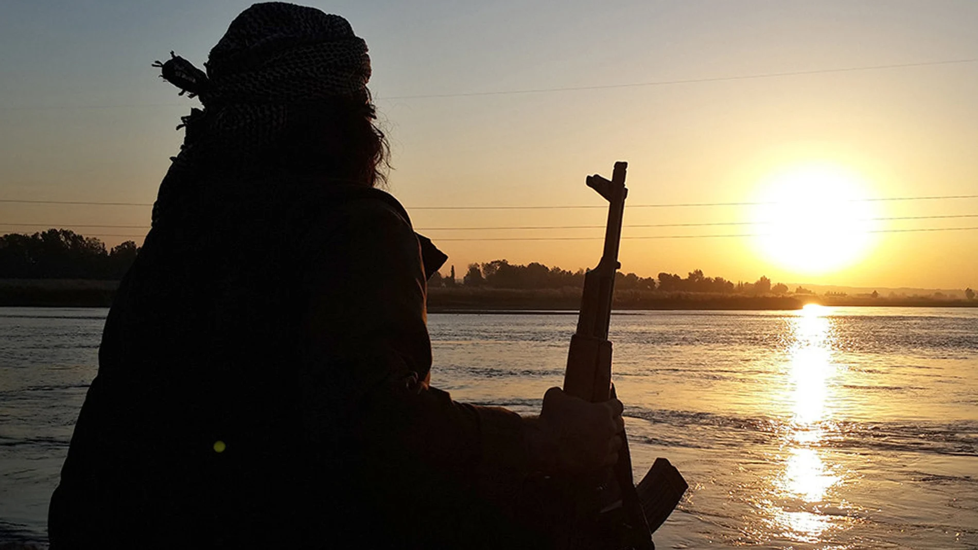 Un yihadista del EI en Raqqa (Siria) posa de espaldas con su AK-47 en 2014