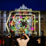 Varias personas disfrutan este viernes del inicio de las proyecciones del pesebre digital en formato de video 'mapping' en la fachada del Ayuntamiento de Barcelona