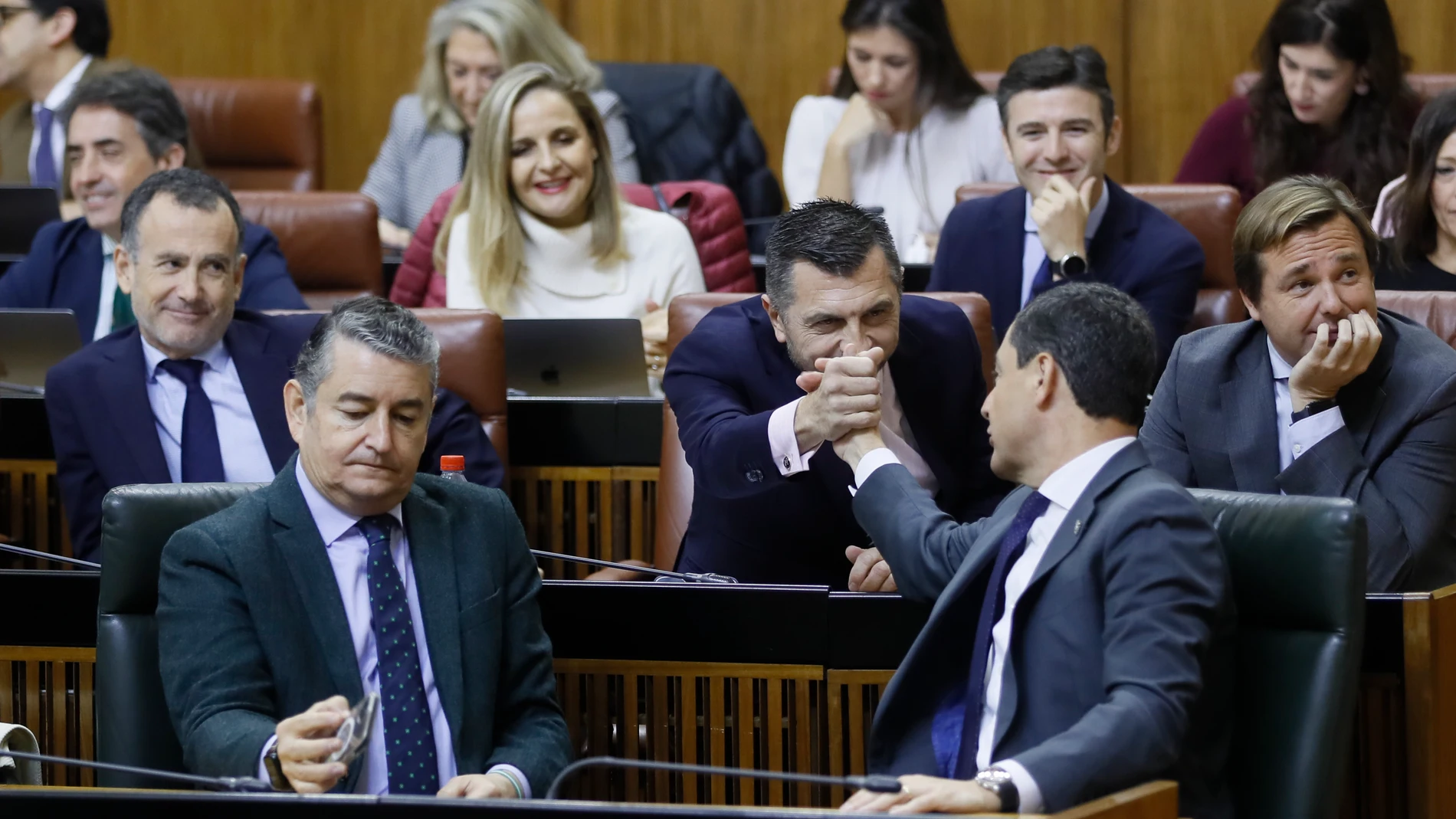 El presidente andaluz, Juanma Moreno (d), felicita al portavoz de su grupo parlamentario, Toni Martín, tras su intervención. EFE/José Manuel Vidal