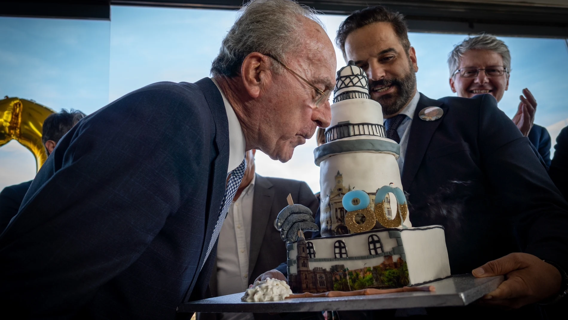 El alcalde de Málaga, Francisco de la Torre (i), sopla las velas de la tarta de sus 80 cumpleaños .EFE/Amparo García