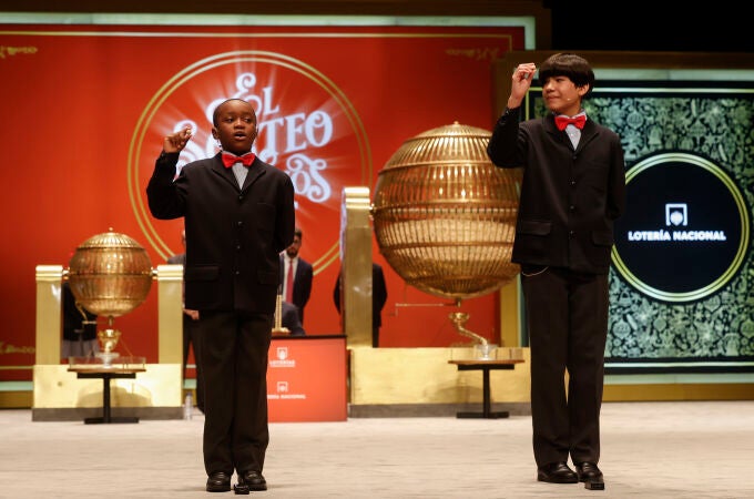 Los estudiantes de San Ildefonso Alonso Dávalos Durán (d) y su compañero Ángel Abaga Elebiyo (i) cantan el premio Gordo durante el sorteo de Navidad en el Teatro Real en Madrid, este jueves