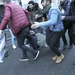 Un hombre que quedó inconsciente durante la protesta es trasladado por varias personas durante un enfrentamiento entre manifestantes y policías en París