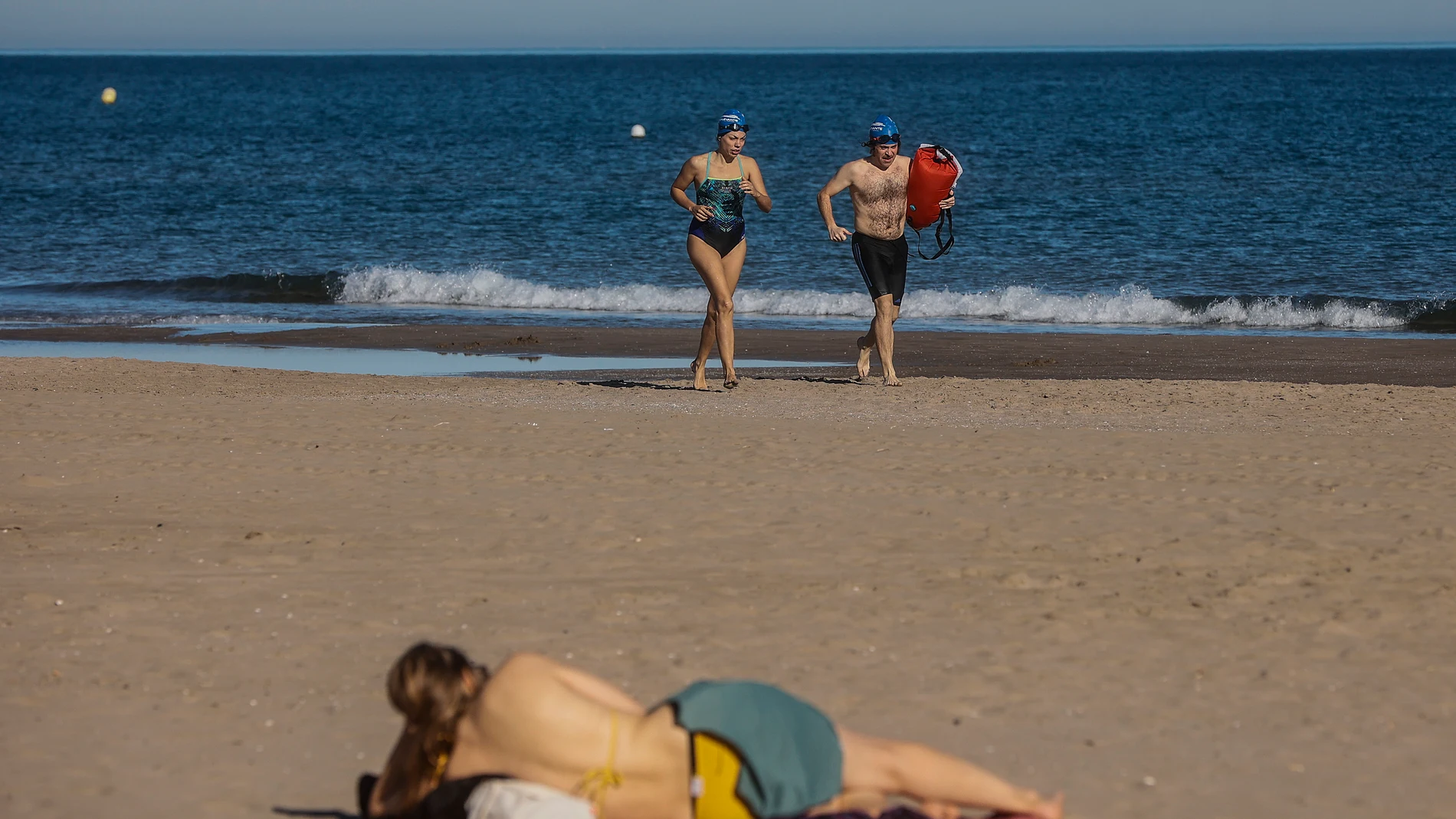Dos personas en bañador caminan por la orilla de la playa, a 24 de diciembre de 2022, en Valencia, Comunidad de Valencia, (España).