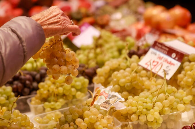 Una mujer escoge un ramillete de uva en el Mercado Central cuando dos de cada tres uvas consumidas procederán este fin de año de la DOP del Vinalopó (Alicante)