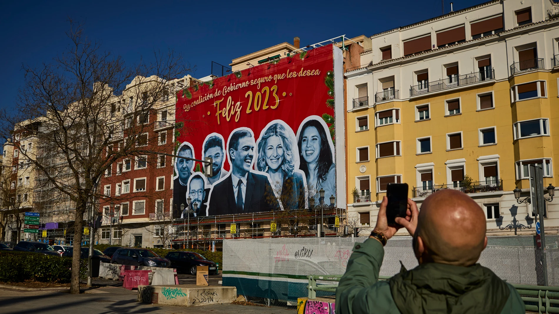 Cartel colgado en un edificio de la calle Ferraz de Madrid en alusiones al Gobierno de coalición del PSOE con el lema “La coalición de gobierno seguro que les desea Feliz 2023”