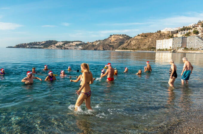 En torno a un centenar de personas de países nórdicos ataviadas con adornos navideños han cumplido en aguas de Almuñécar (Granada) con su tradición de recibir el nuevo año con un baño en agua. EFE/ Alba Feixas