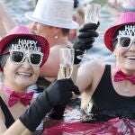 Geneva (Switzerland), 01/01/2023.- People toast with champagne while swimming in the cold water during the New Year's traditional swimming in the Lake of Geneva at the Bains des Paquis, in Geneva, Switzerland, 01 January 2023. (Suiza, Ginebra) EFE/EPA/SALVATORE DI NOLFI