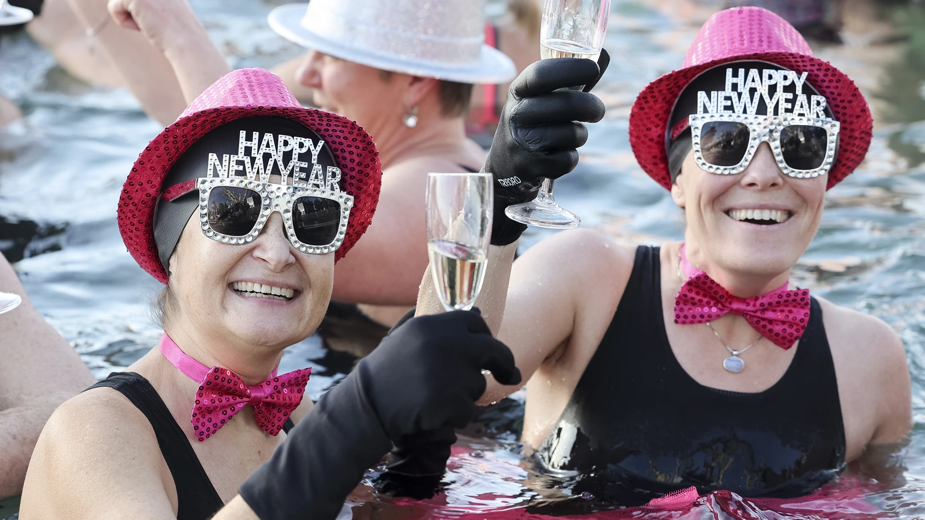 Geneva (Switzerland), 01/01/2023.- People toast with champagne while swimming in the cold water during the New Year's traditional swimming in the Lake of Geneva at the Bains des Paquis, in Geneva, Switzerland, 01 January 2023. (Suiza, Ginebra) EFE/EPA/SALVATORE DI NOLFI